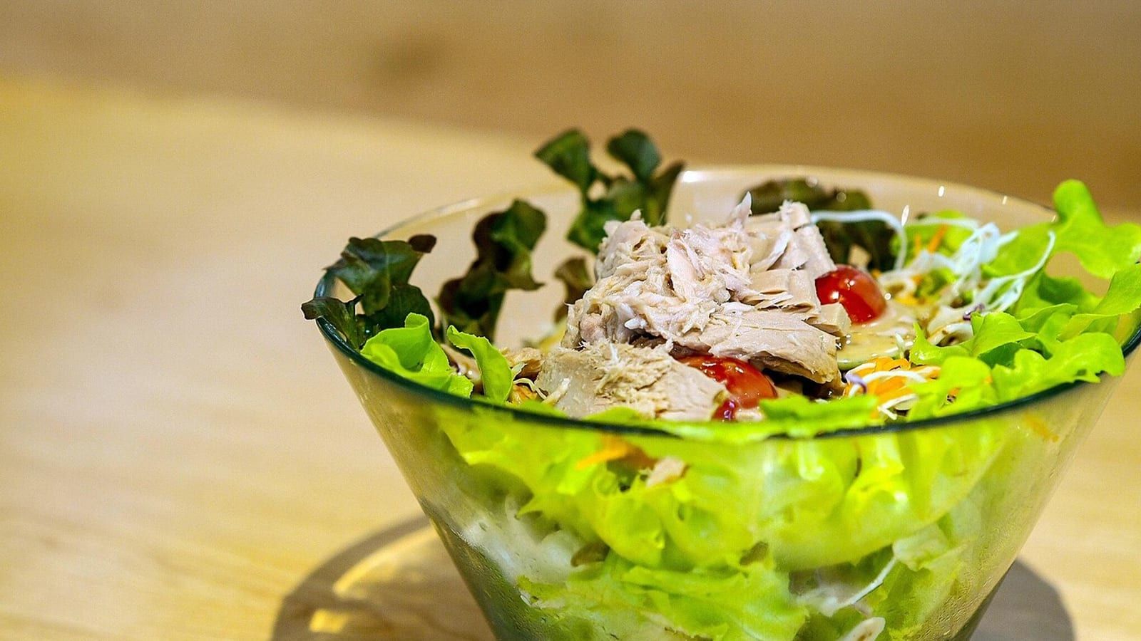 Ensalada de atún y aceitunas servido en un plato con presentación sencilla.