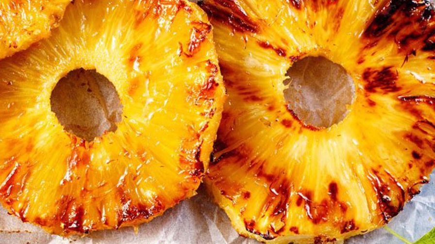 Rodajas de piña asada con canela servidas en un plato.