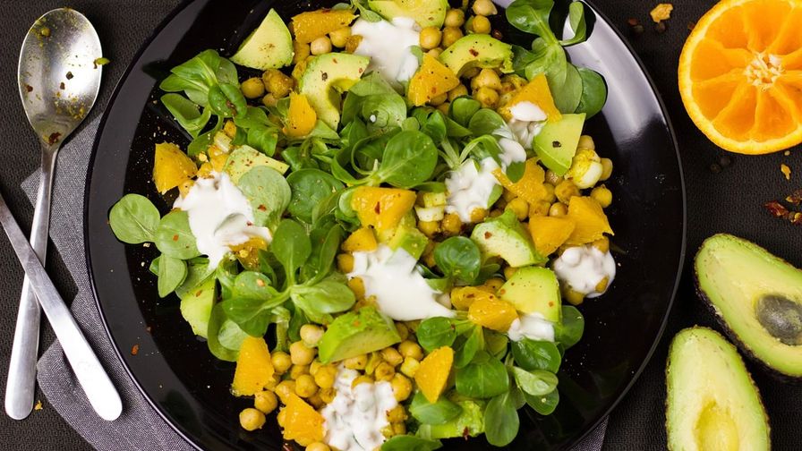 Ensalada de garbanzos y verduras servido en un plato con presentación sencilla.
