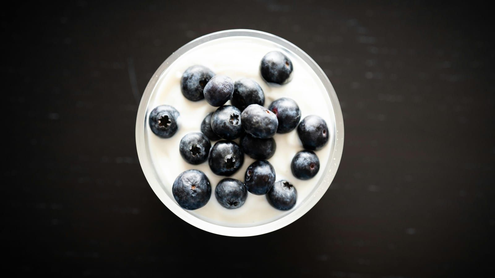Yogur natural con frutos rojos servido en un plato con presentación sencilla.