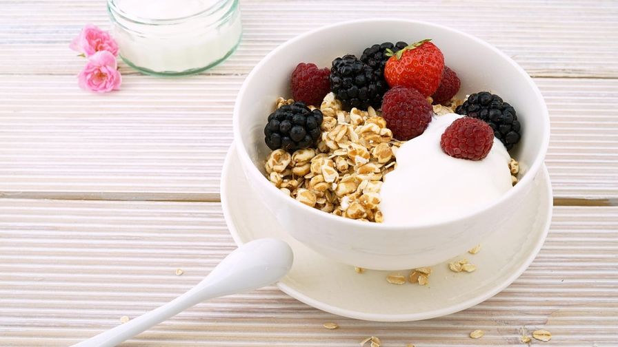 Yogur con fruta y avena servido en un plato con presentación sencilla.