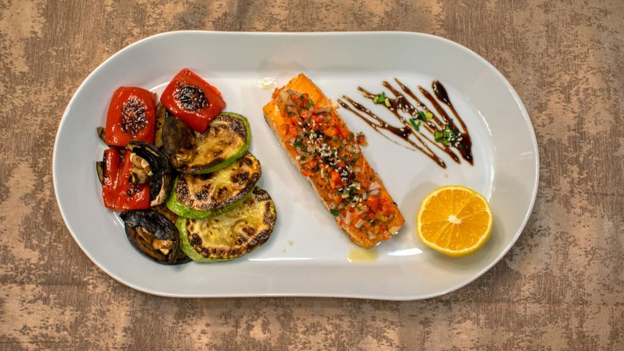 Salmón con patata y espinacas servido en un plato con presentación sencilla.