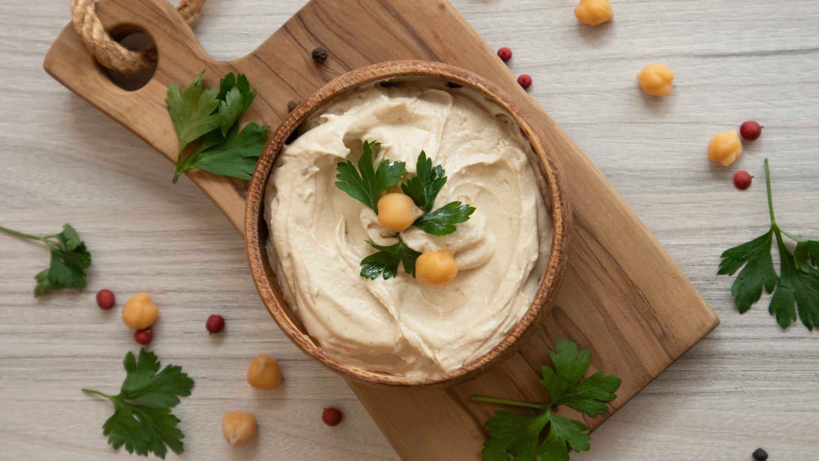 Hummus con bastones de zanahoria servido en un plato con presentación sencilla.