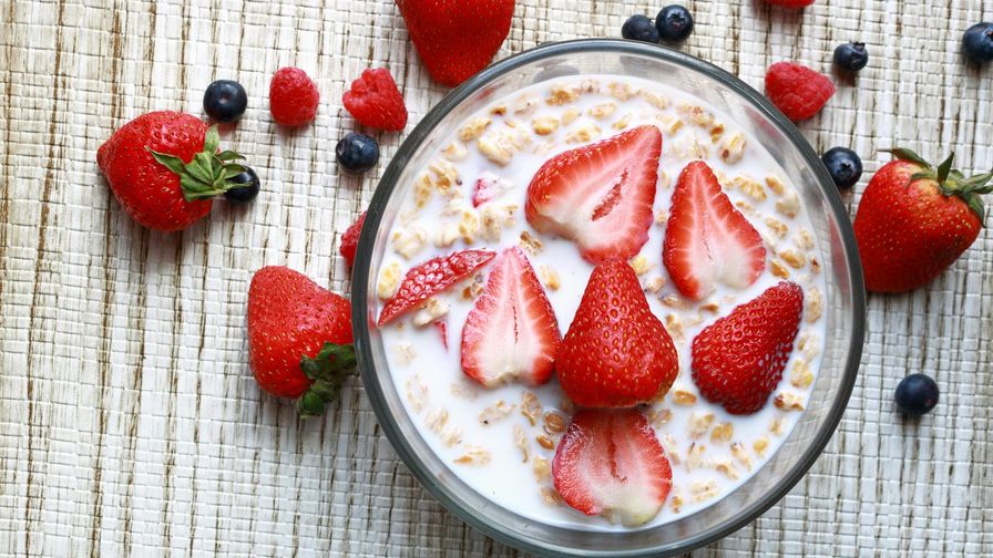 Avena con bebida de soja y frutos rojos servido en un plato con presentación sencilla.