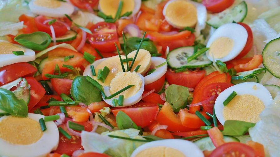 Ensalada de huevo y tomate servido en un plato con presentación sencilla.