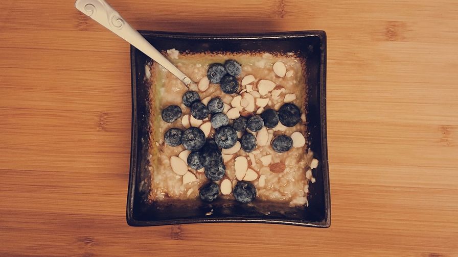 Avena con arándanos y almendras servido en un plato con presentación sencilla.