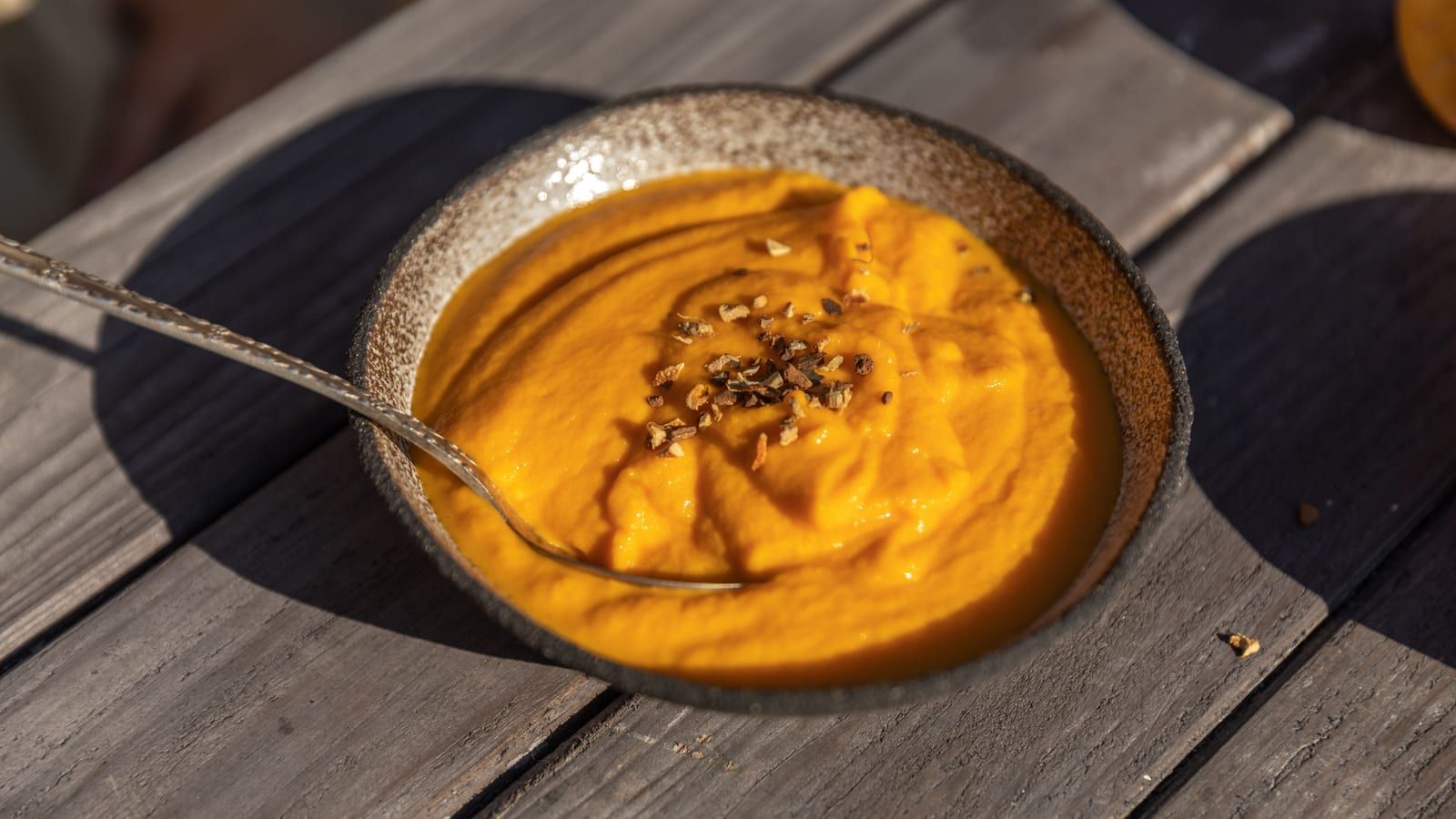 Crema de calabaza y zanahoria servido en un plato con presentación sencilla.