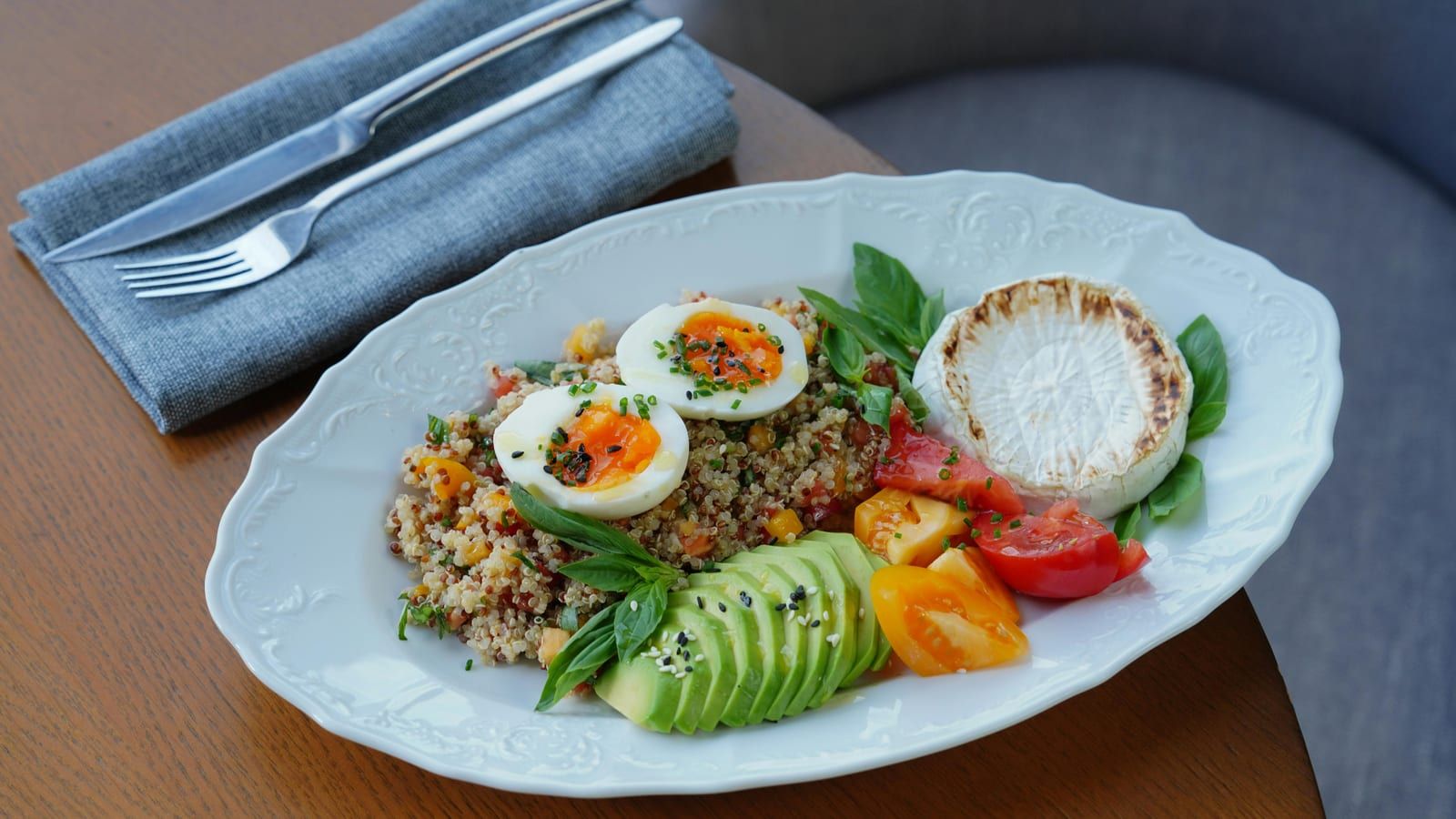Ensalada de quinoa, pepino y aguacate servido en un plato con presentación sencilla.