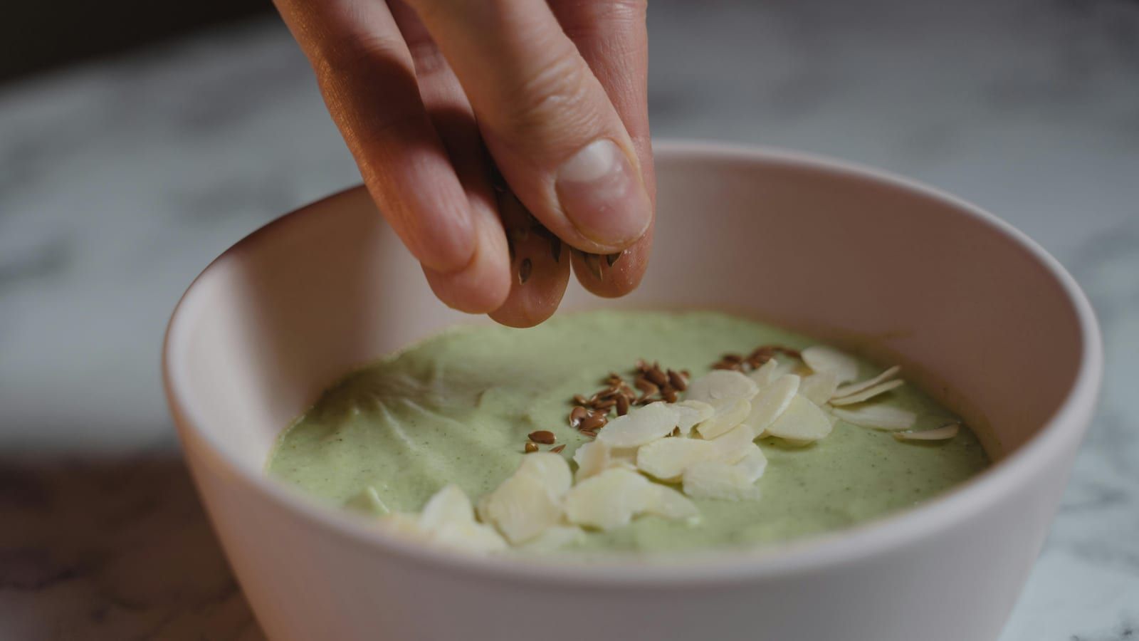 Crema de calabacín con almendras servido en un plato con presentación sencilla.
