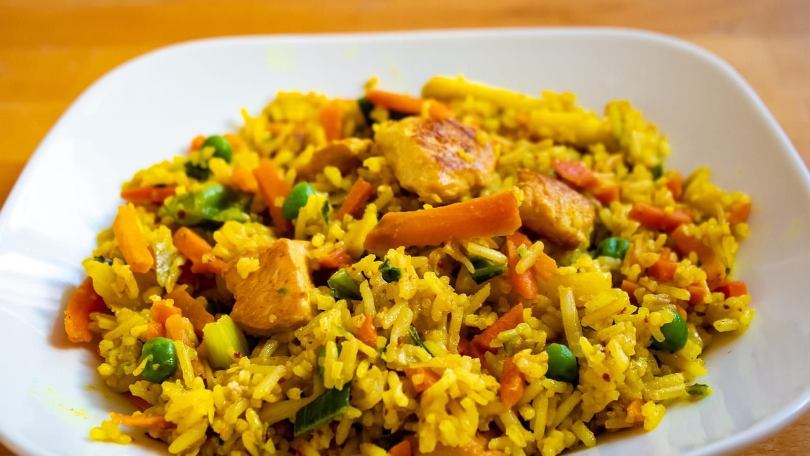Pollo con arroz integral servido en un plato con presentación sencilla.