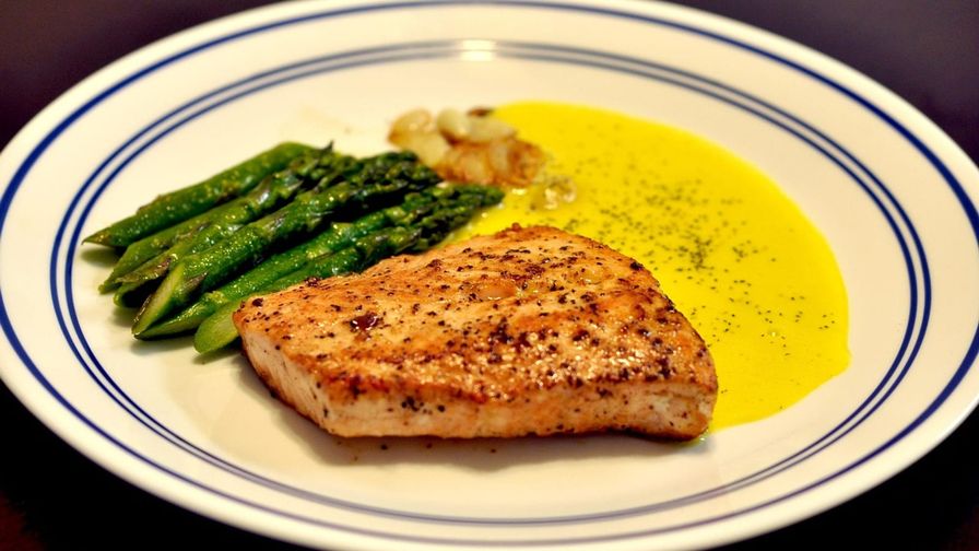 Salmón con espárragos servido en un plato con presentación sencilla.