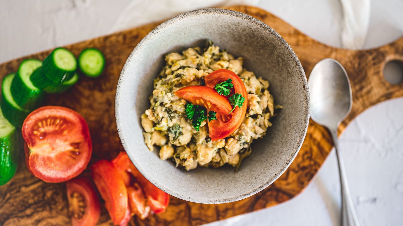 Ensalada de garbanzos y pollo servido en un plato con presentación sencilla.