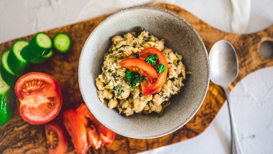 Ensalada de garbanzos y pollo servido en un plato con presentación sencilla.